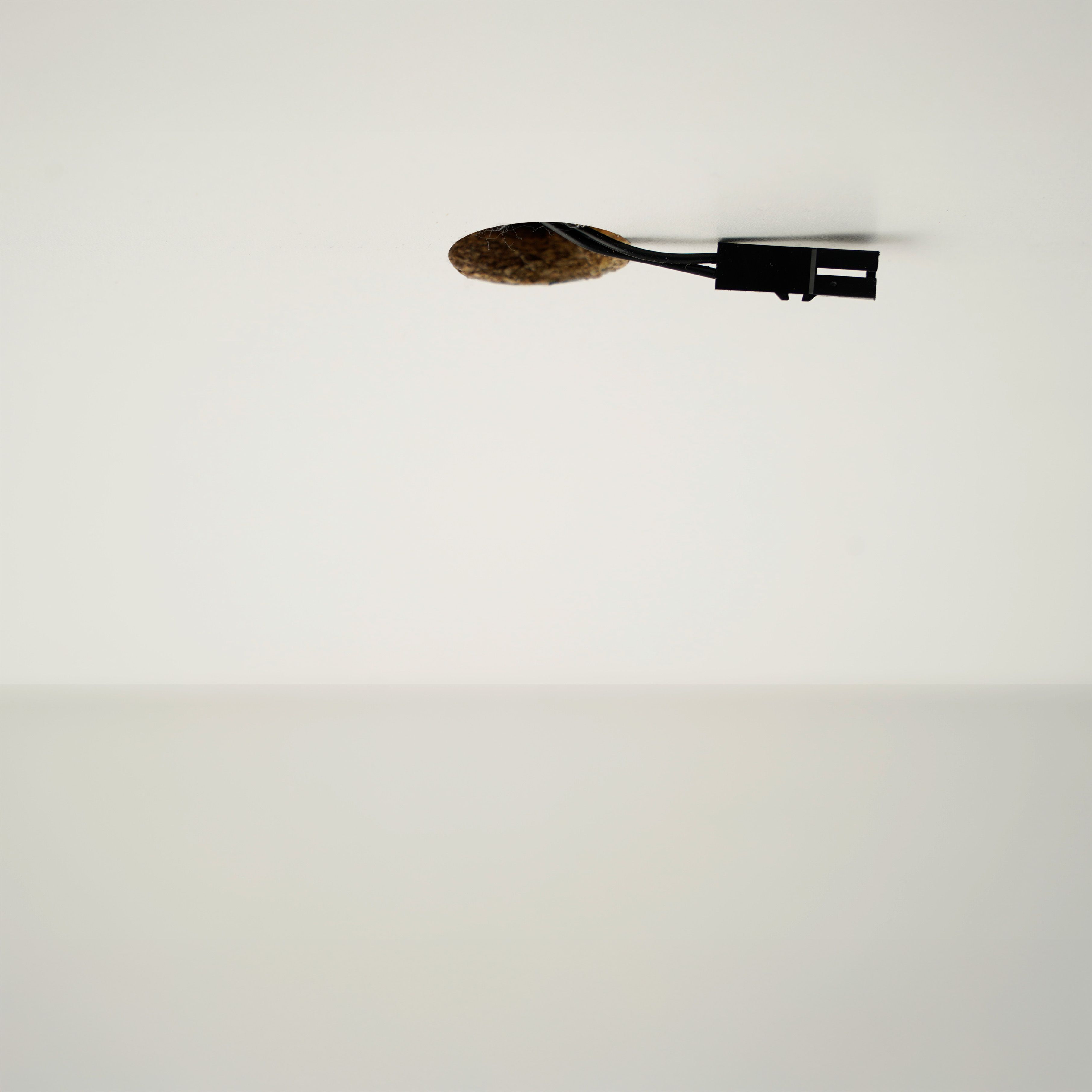 Elektrabedrading die uit een plafondgat steekt voor het aansluiten van een mini LED-inbouwspot