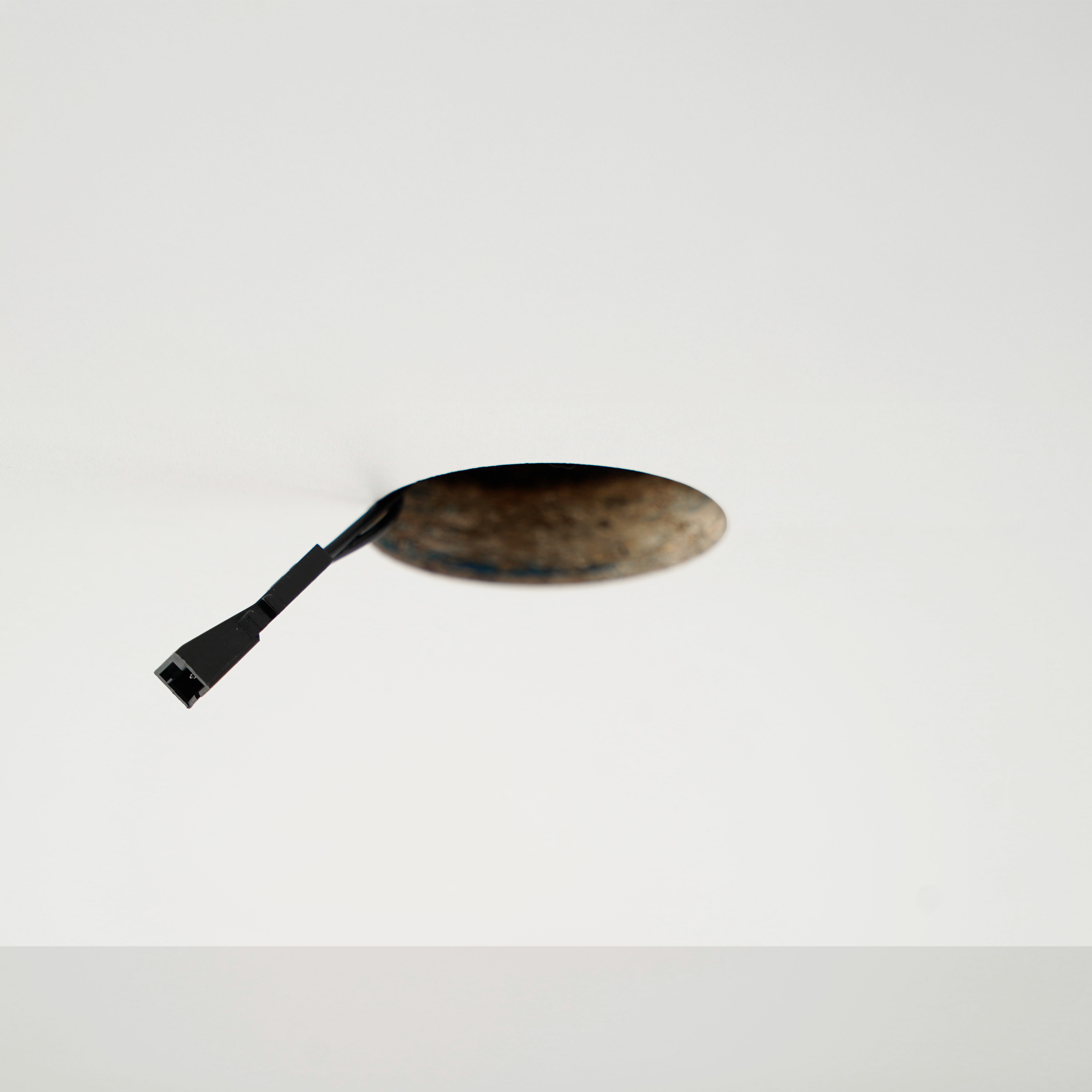 Elektradraad uit plafondopening voorbereiden voor installatie van een LED-inbouwspot