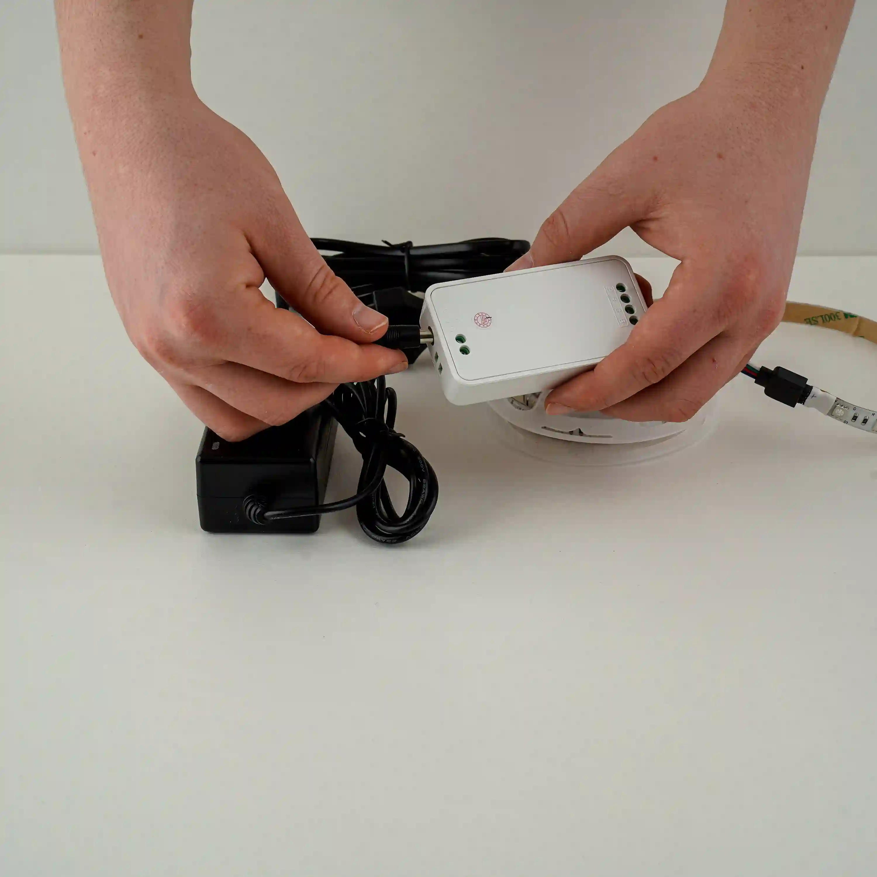 Voedingsadapter aansluiten op LED-strip controller voor stabiele stroomvoorziening van LED-verlichting