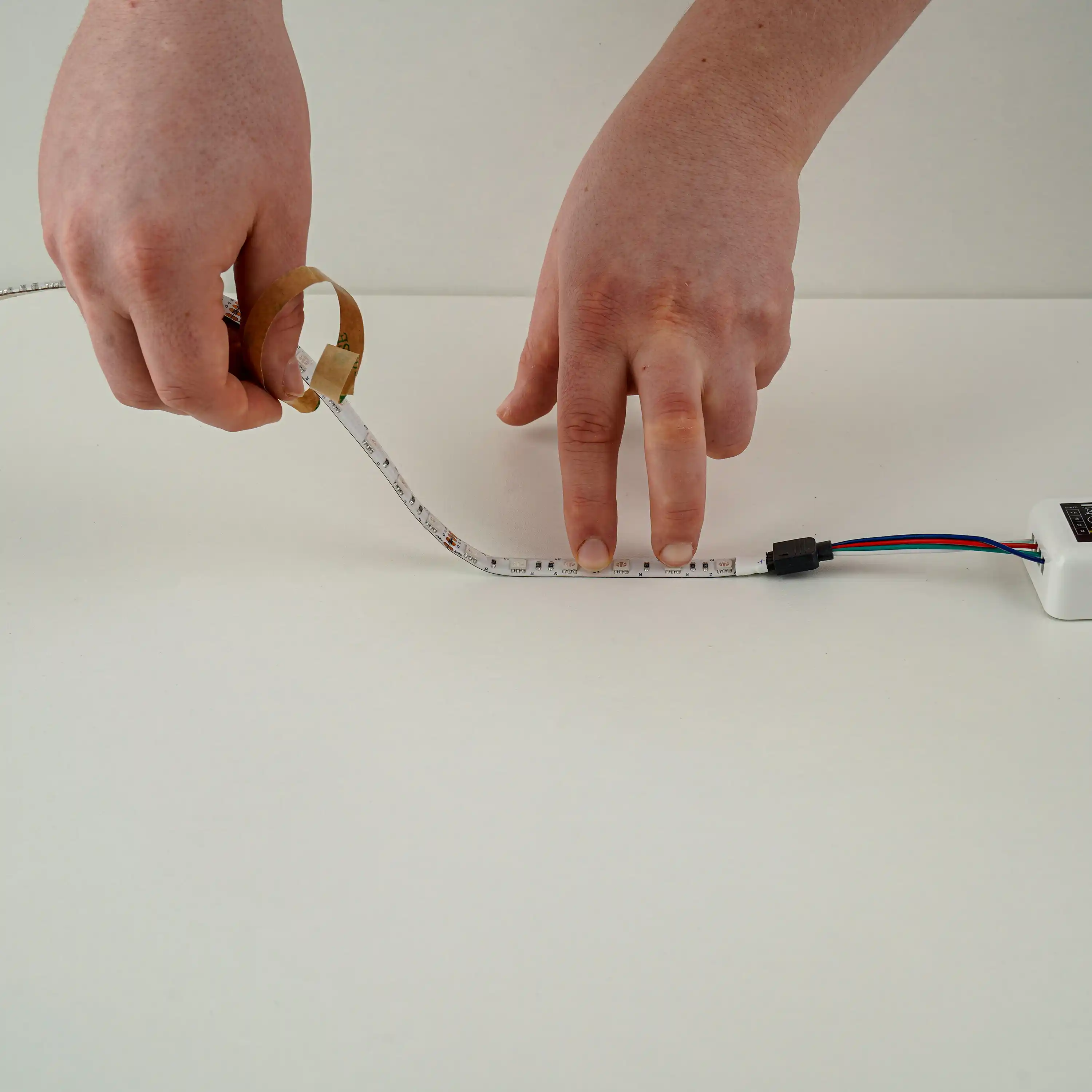 LED-strip bevestigen door de beschermlaag van de plakstrip te verwijderen voor eenvoudige montage