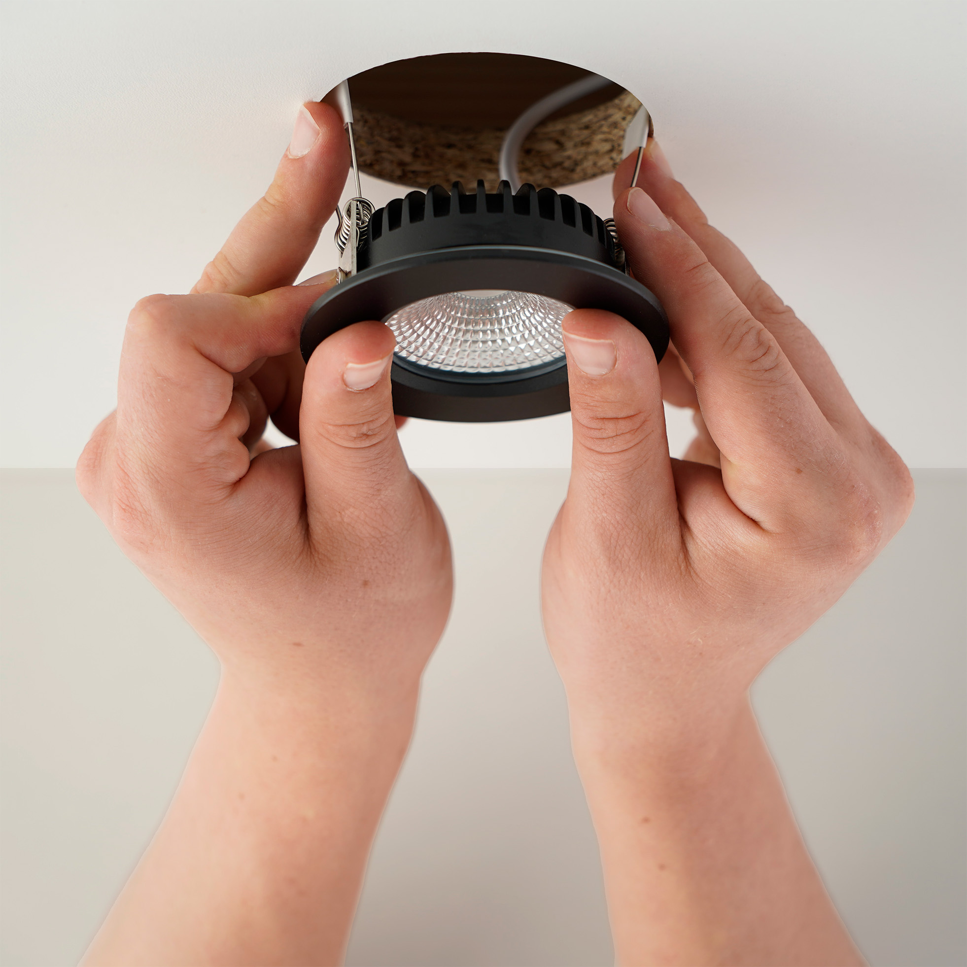 Waterdichte LED-inbouwspot in het plafond plaatsen door de spot in het montagegat te drukken