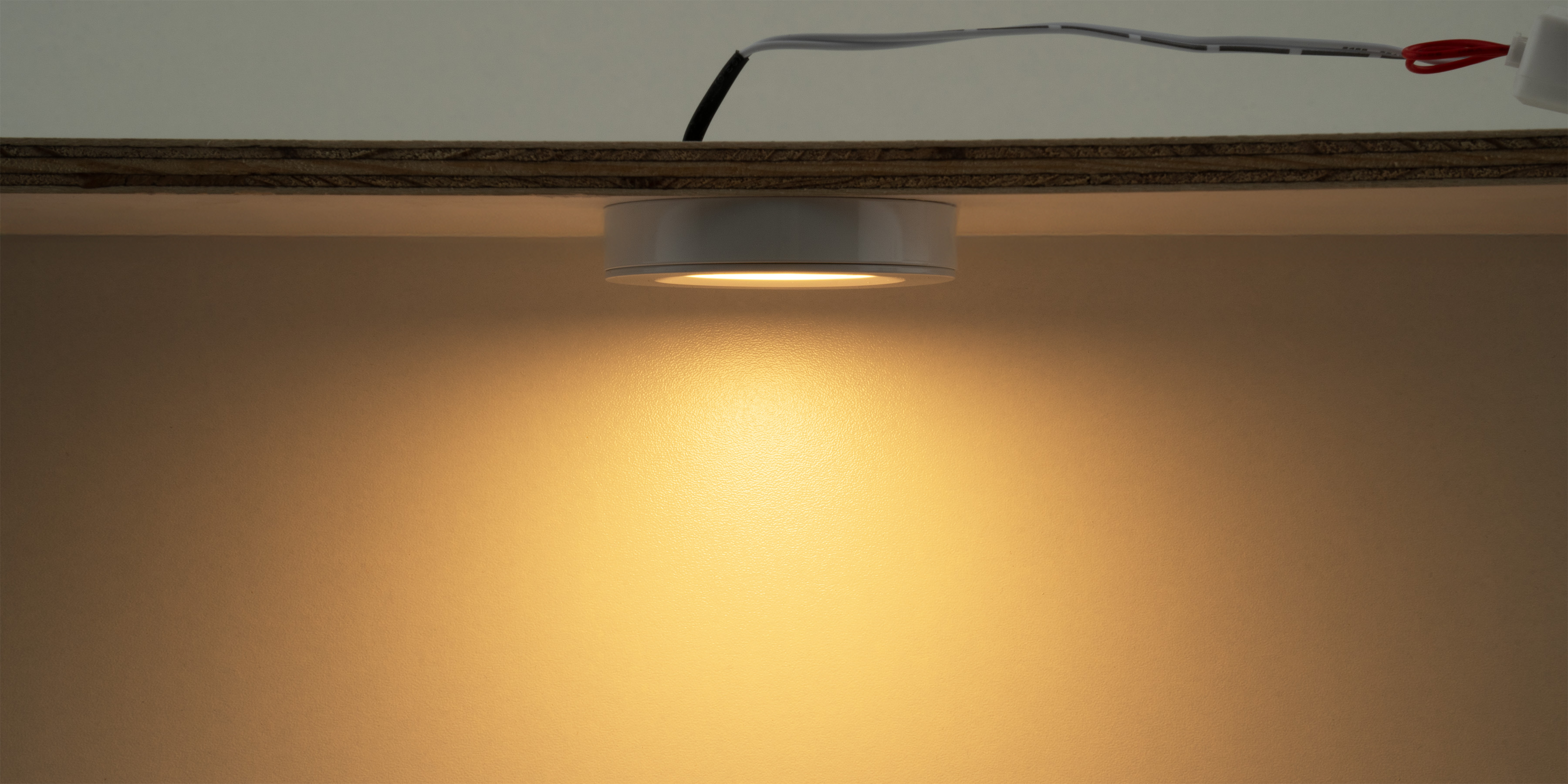 Mini LED-opbouwspot onder plank gemonteerd die warm licht naar beneden schijnt voor gerichte verlichting